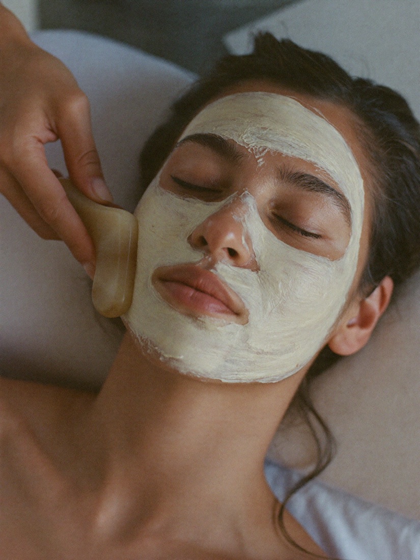 A facial with a soft clay mask, finished with gua sha along the cheek