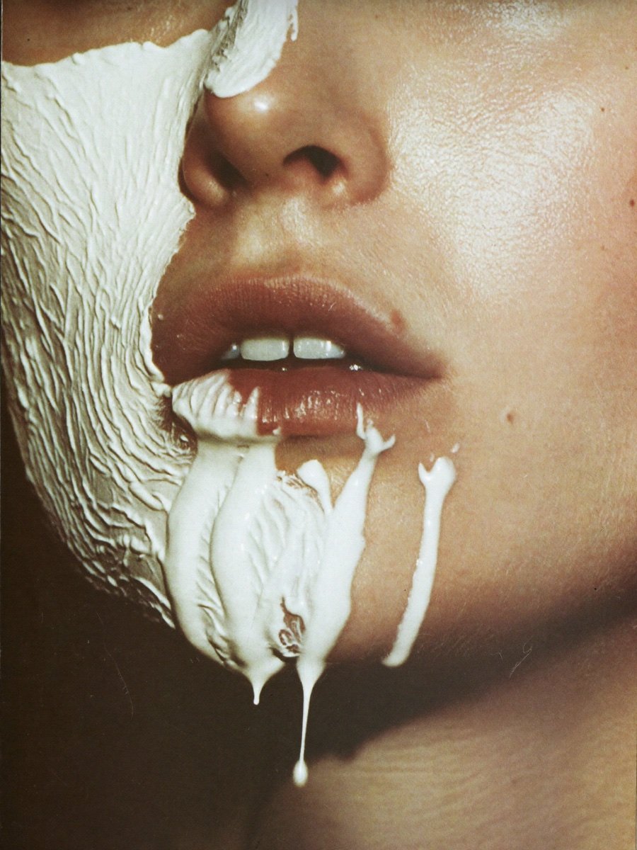 Thick white mask cream dripping slowly over lips and chin